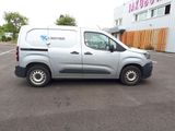 une camionnette grise garée sur un parking devant un immeuble