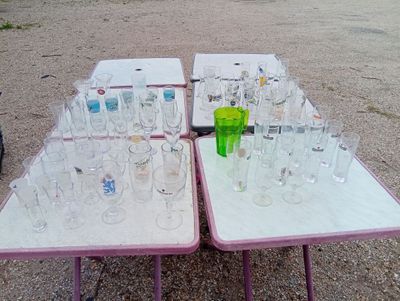many empty wine glasses on a table in a parking lot