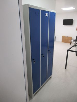 deux casiers bleus dans une pièce où se trouve un ordinateur posé sur le bureau