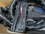 a box with a vacuum, hose, and other items in it