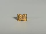 gros plan d'une bague en or sur une surface blanche