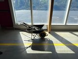a wheelbarrow in the middle of a room with a lot of windows