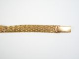 a close up of a gold bracelet on a white surface