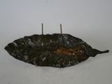 un bougeoir en forme de feuille sur lequel est posée une bougie