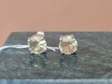 boucles d'oreilles plaquées argent ornées de cristaux transparents sur un fond en marbre