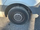 une camionnette blanche qui a un pneu crevé