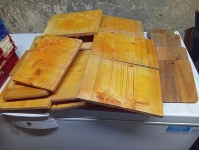 several pieces of wood are stacked on top of a refrigerator