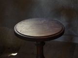 a small table with a wooden top in a dark room
