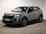 Le SUV gris est garé dans une grande pièce au sol carrelé en damier.