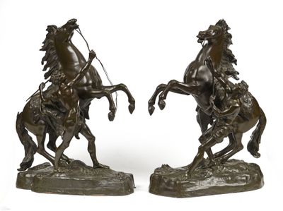 une paire de sculptures en bronze représentant un homme à cheval et une femme à cheval