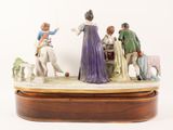 a figurine of a group of people playing with a dog