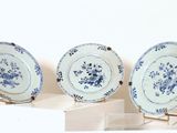 trois assiettes bleues et blanches exposées sur une étagère