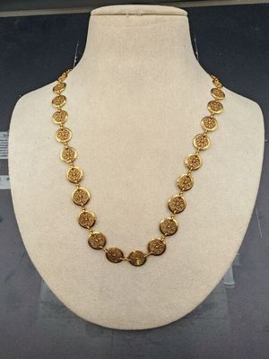 un collier en or exposé dans une vitrine