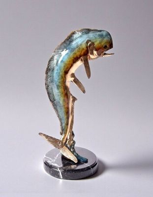 statue of a dolphin on a stand on a white surface