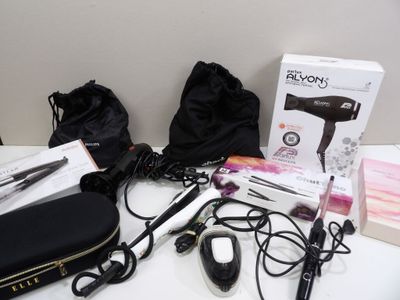 le contenu d'un sèche-cheveux, d'un sèche-cheveux et d'autres objets posés sur une table
