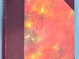 an orange and red book sitting on top of a white table