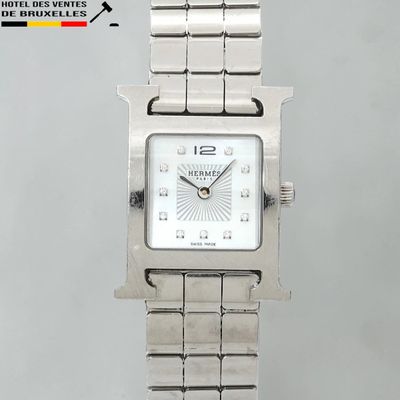 une montre en argent avec un cadran blanc et un bracelet en argent