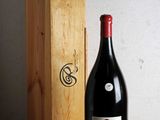 une bouteille de vin posée sur une table à côté d'une caisse en bois