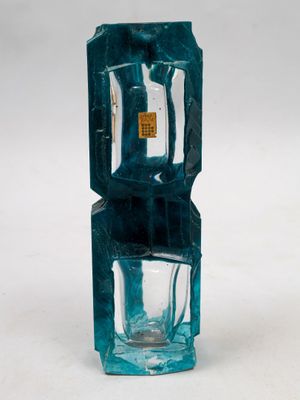 un vase en verre bleu contenant un petit verre à l'intérieur