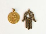 deux bijoux en or et diamants posés sur un fond blanc