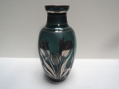 un vase bleu orné de fleurs noires et blanches