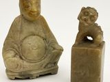 une petite statue représentant un homme assis à côté d'une petite statue représentant un chien