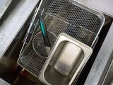 a metal sink with a metal basket in the middle of it