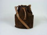 a brown sued bucket bag with a tan leather strap