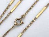 a close up of a group of gold chains on a white surface