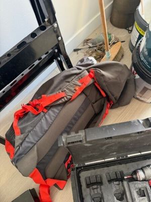 une valise contenant des outils, posée par terre à côté d'une chaise