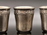 three silver cups sitting on top of a table next to each other