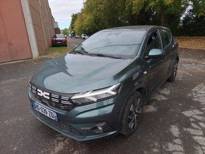 La voiture verte est garée sur le bord de la route.