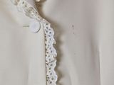 a close up of a white jacket with a red tie