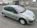 La petite voiture est garée sur le parking situé devant un immeuble.