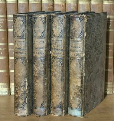 trois livres posés sur une étagère devant une pile de livres