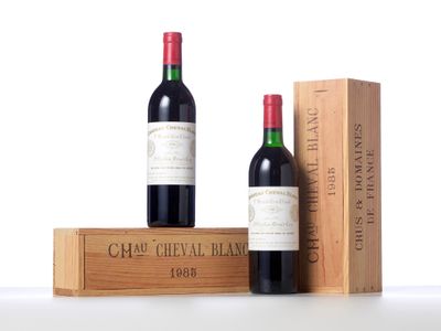 two bottles of red wine sit next to a wooden box