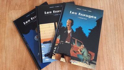 three books sitting on top of a wooden table next to each other