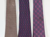 three ties are lined up in a row on a white surface