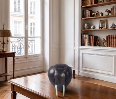 une photo d'un salon avec une table basse et une bibliothèque