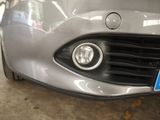 a close up of a car ' s headlight with a blue sticker on it