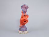 a red and blue sculpture of a human head on a gray surface