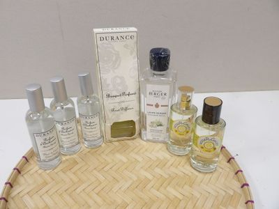 des flacons de parfum posés sur un plateau en bambou, lui-même posé sur une table