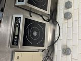 two microwaves sitting on top of a stove in a kitchen
