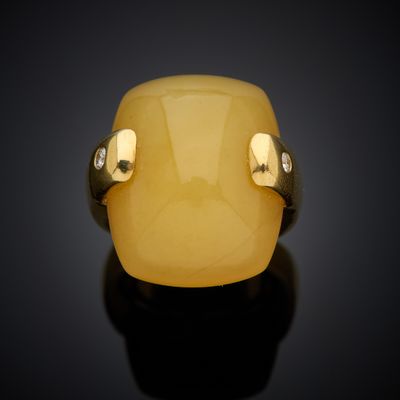 a close up of a yellow jade ring on a black surface