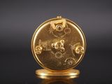 a close up of a gold plated clock on a black surface