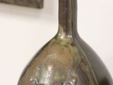 a vase that is sitting on a table in front of a painting