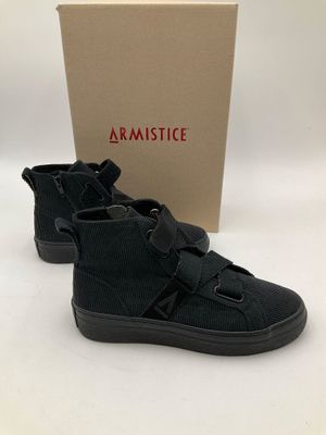 une paire de baskets noires avec une boîte en arrière-plan