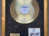 gold record in a gold frame with a picture of a man in a suit and tie