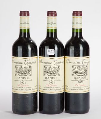 trois bouteilles de vin sont alignées sur une surface blanche