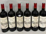six bottles of wine are lined up in a row on a table